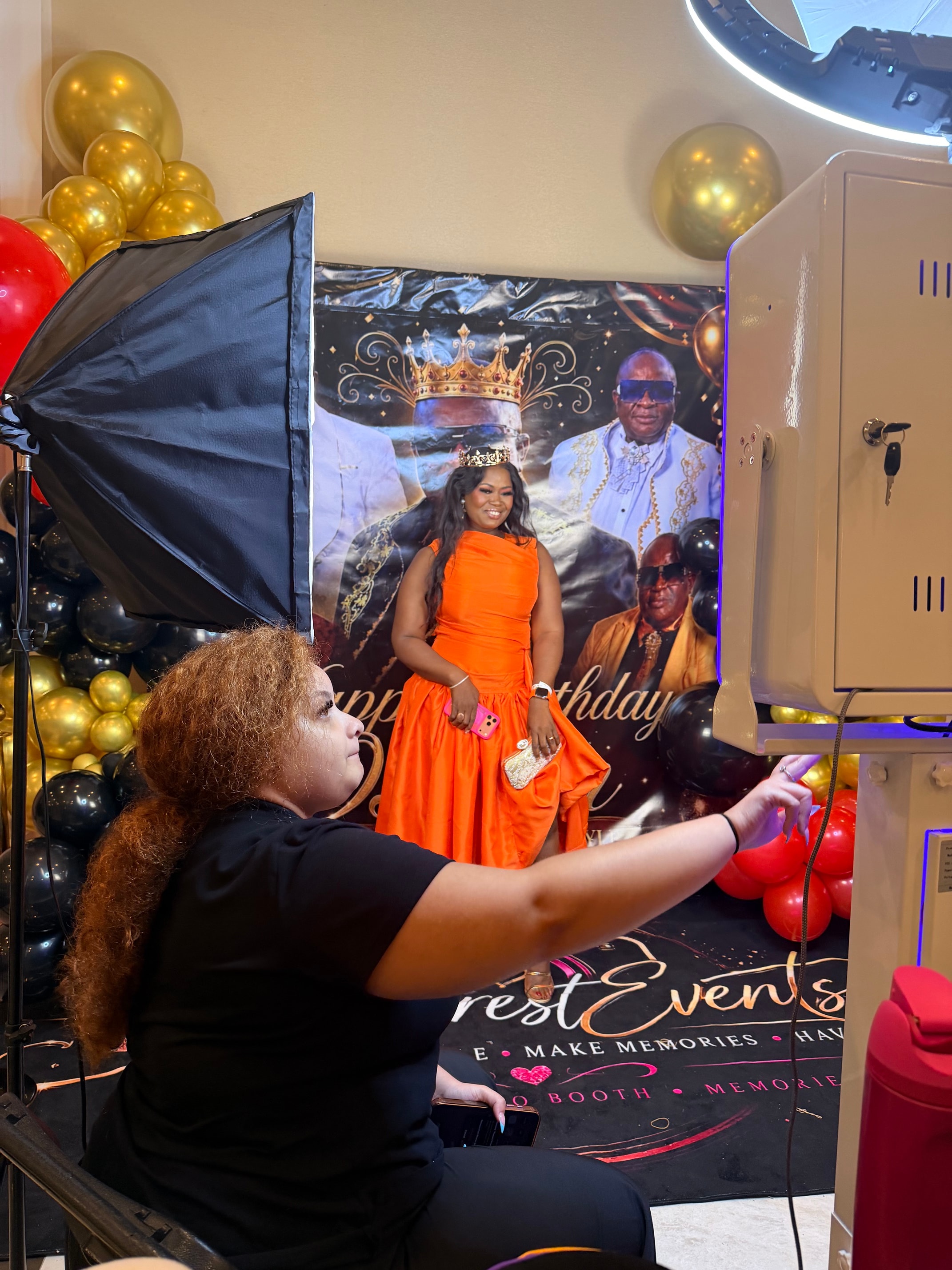 Guest posing at photo booth in orange dress