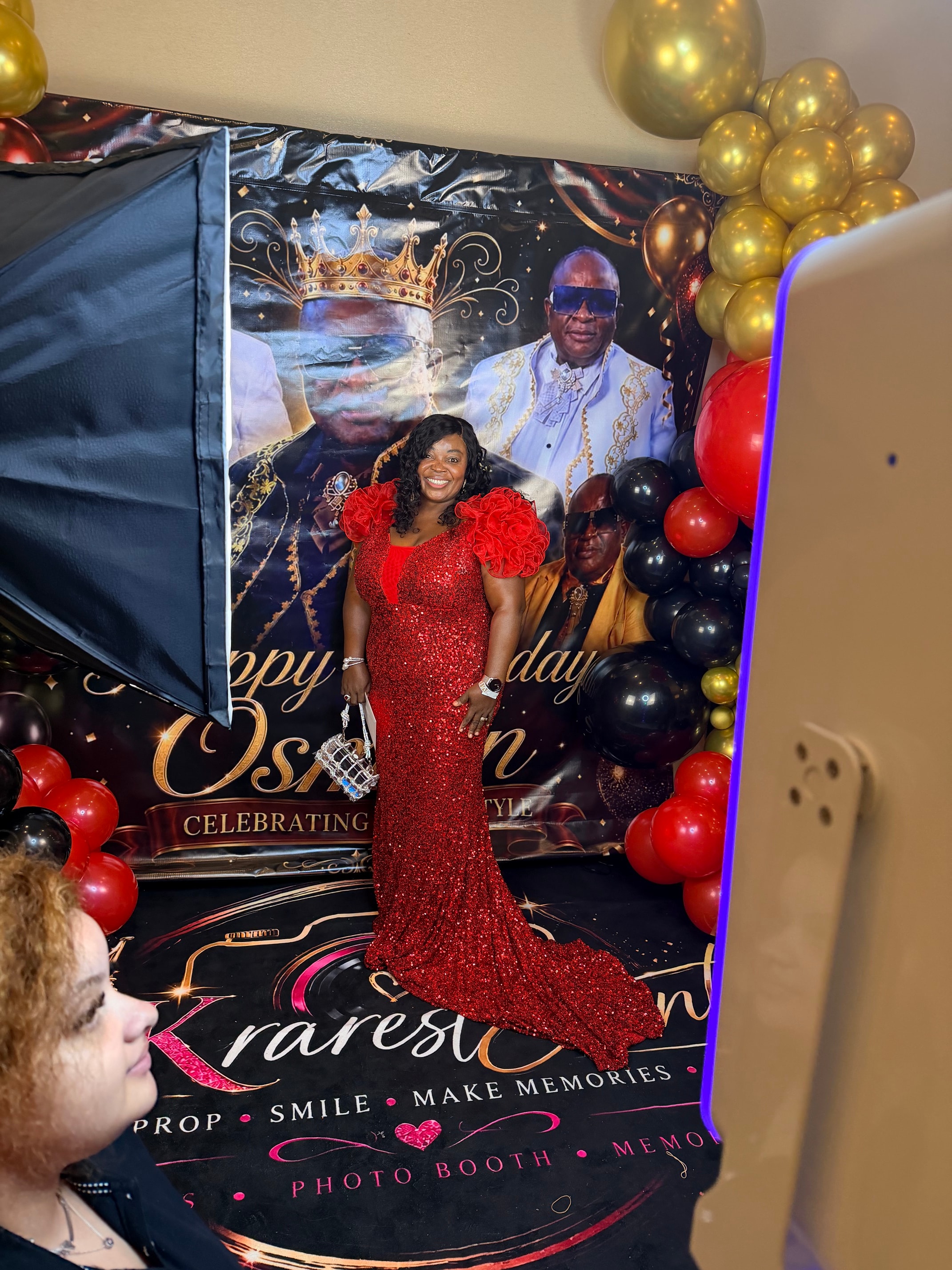 Guest in red sequined gown posing at birthday photo booth
