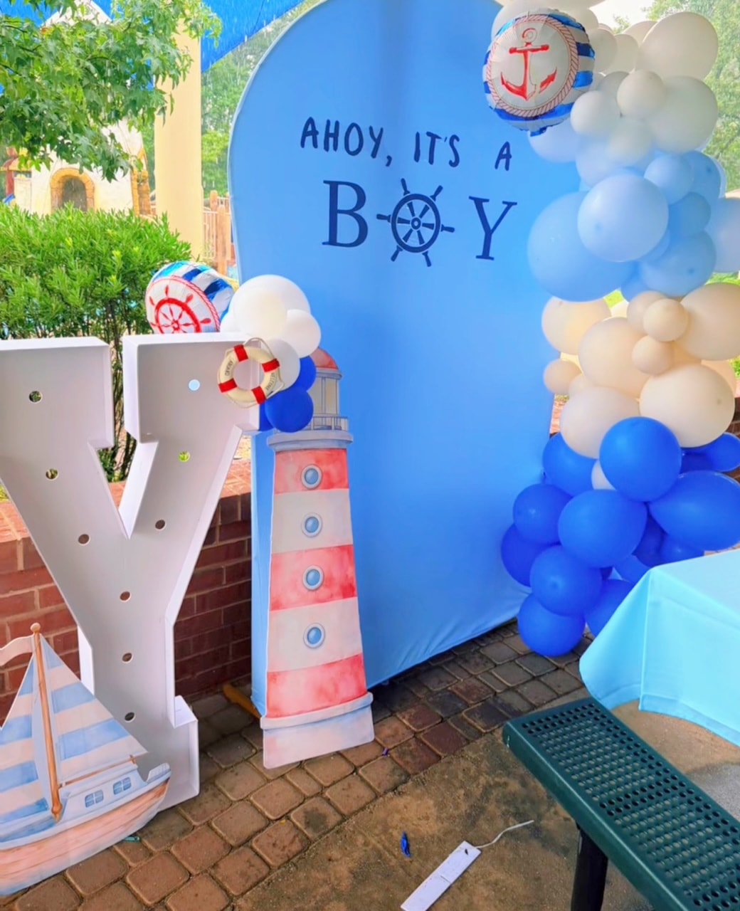 Nautical baby shower backdrop with blue and white balloon arch