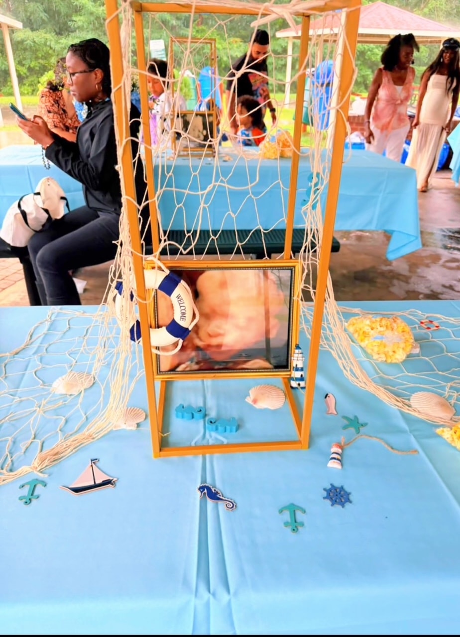 Nautical baby shower table centerpiece with fish net, ultrasound photo, and ocean décor