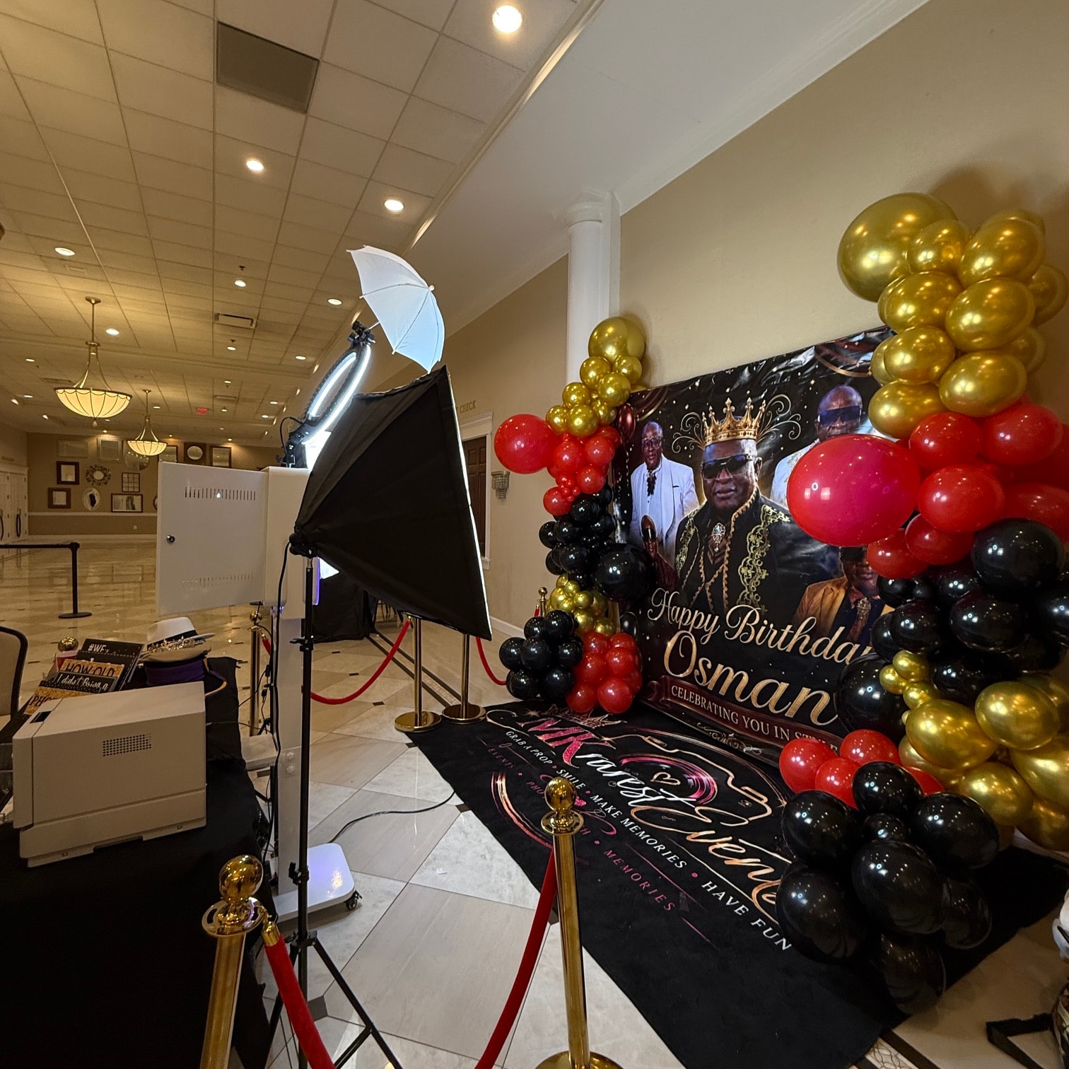 Happy Birthday Osman photo booth setup with gold, red, and black balloons